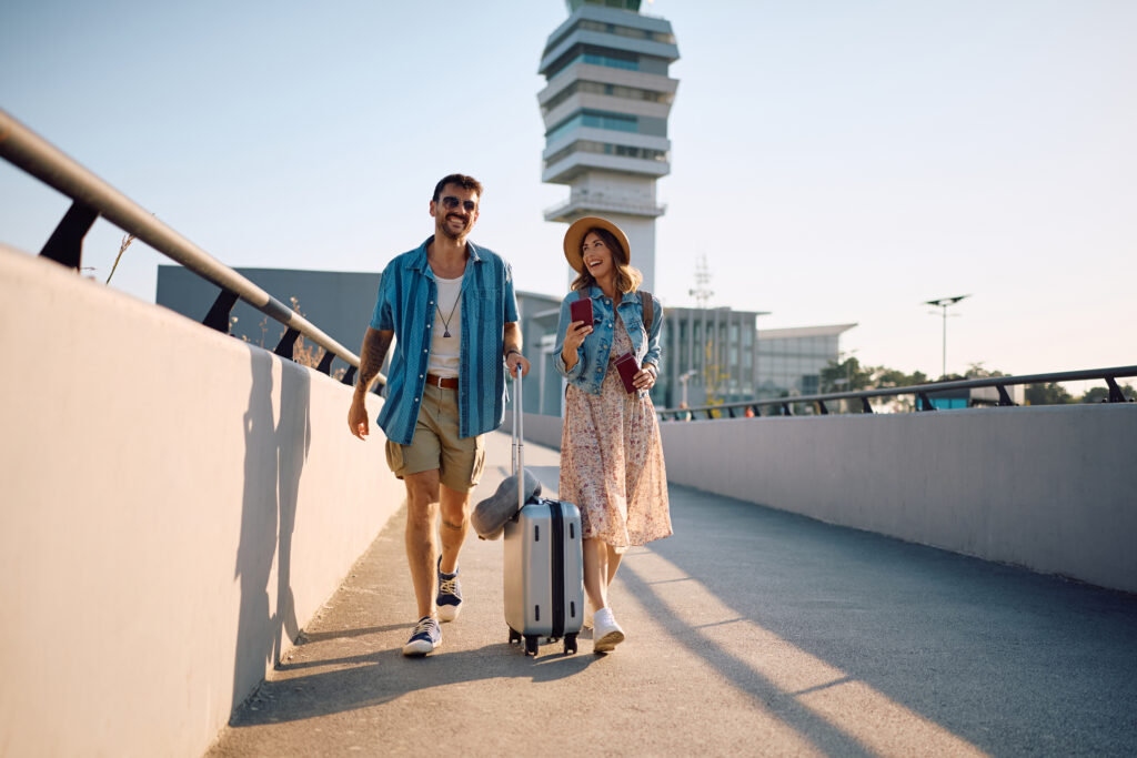 Happy couple of travelers arriving at the airport.