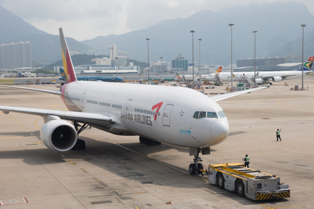 Hong Kong, China - September 24, 2013: Asiana Airlines Boeing 777-200ER at Hong Kong International Airport, Hong Kong. It is one of South Korea's two major airlines. Some ground staffs are working at the airport.