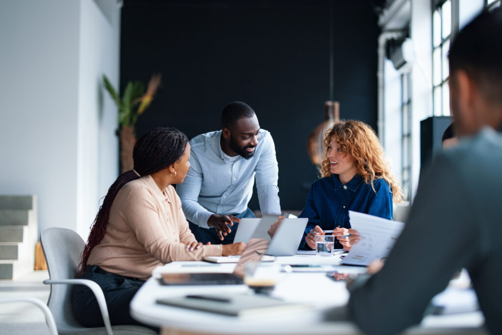 A group of colleagues working together in a contemporary office environment, focused on collaboration and teamwork to achieve professional goals. This setting embodies a productive and dynamic workplace atmosphere.