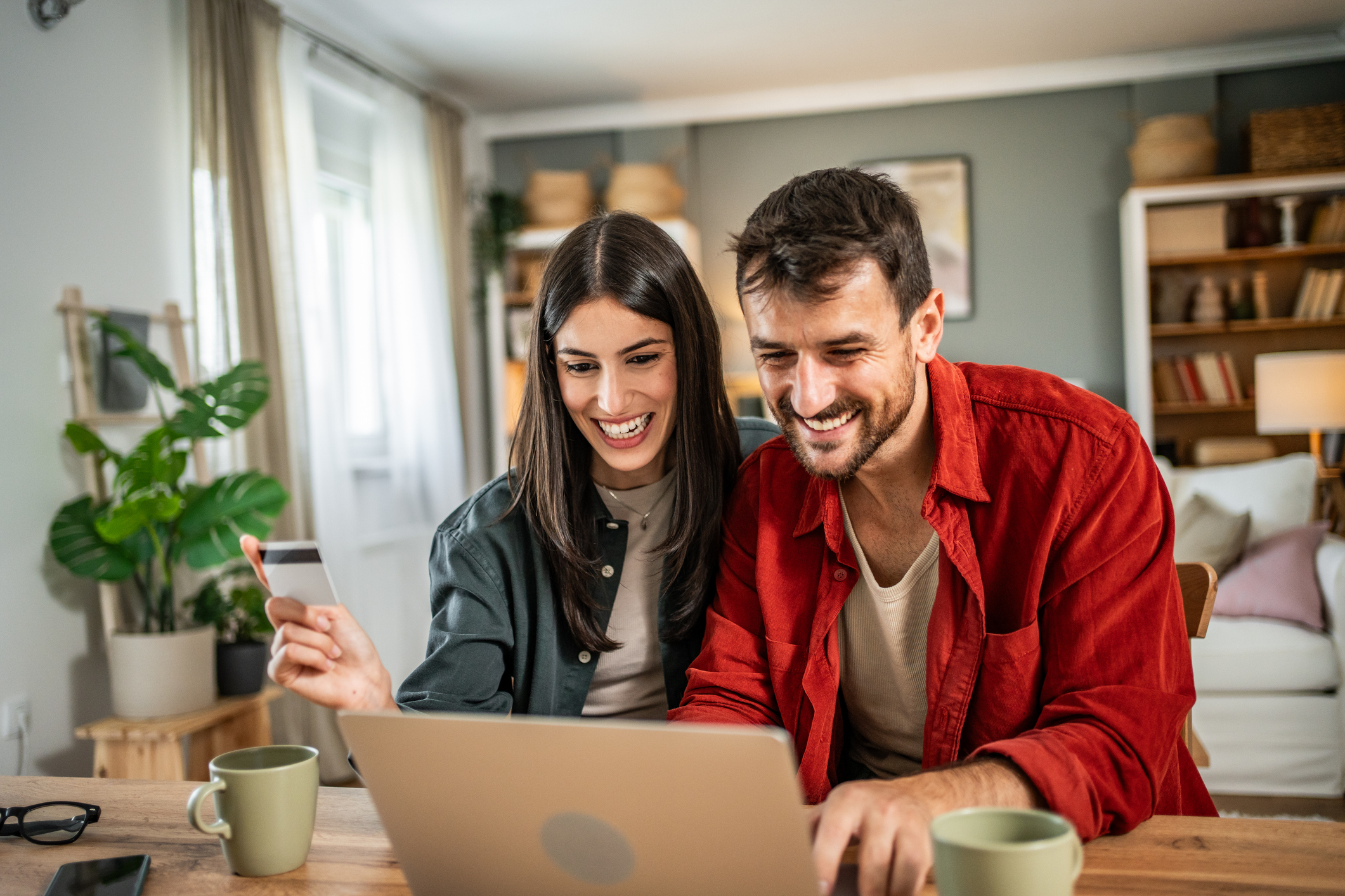 Young couple shopping online at home. Young couple shopping online with credit card and laptop.