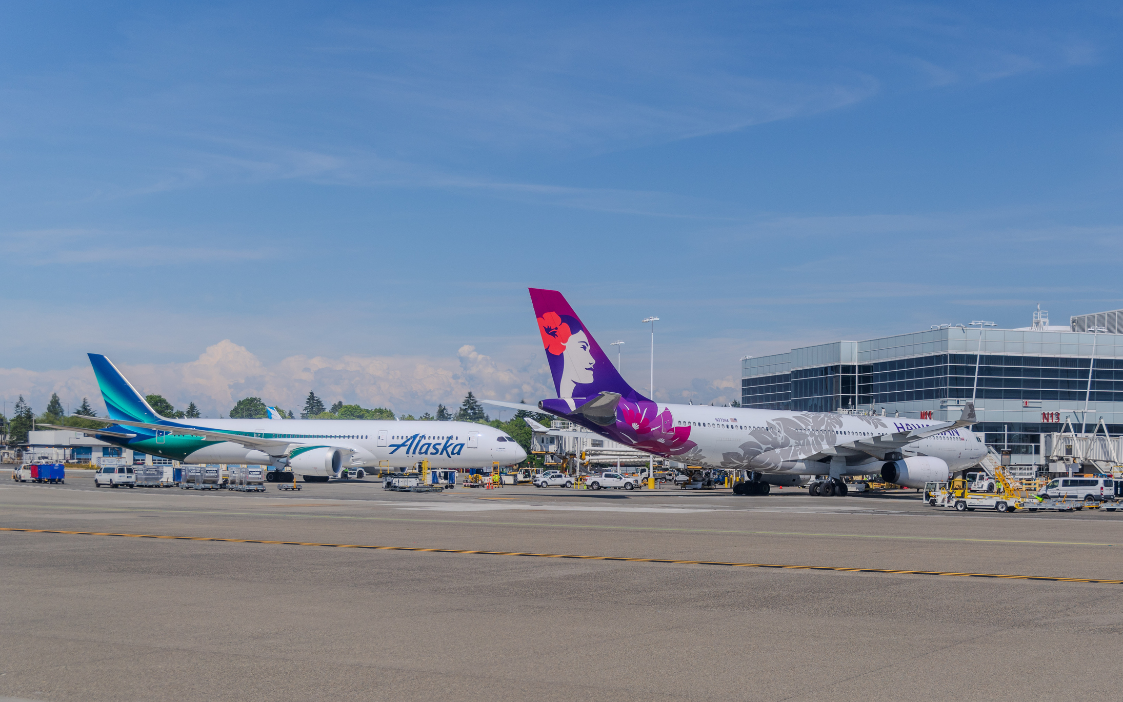 An Alaska Airlines plane and a Hawaiian Airline plane at the gates of Seattle-Tacoma International Airport.